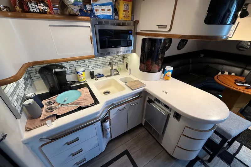 Slide: The Image of Compact kitchen in a 1994 Sea Ray 500 Sundancer yacht with modern appliances and cozy seating. - 30