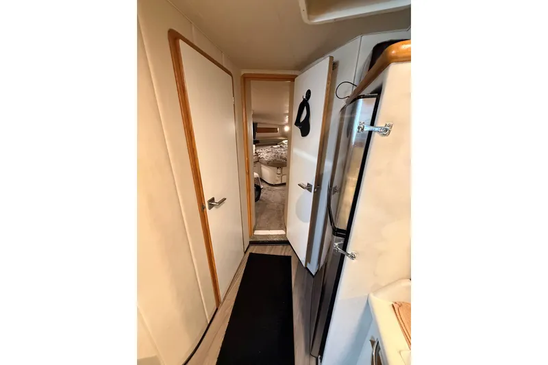 Slide: The Image of Interior hallway of a 1994 Sea Ray 500 Sundancer yacht, featuring doors and a refrigerator. - 40