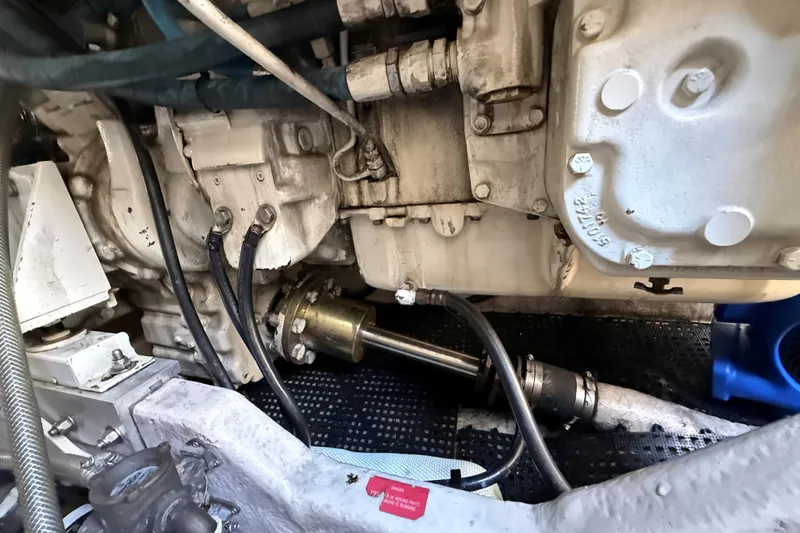 Slide: The Image of Engine compartment of a 1994 Sea Ray 500 Sundancer, showcasing mechanical components and hoses. - 56