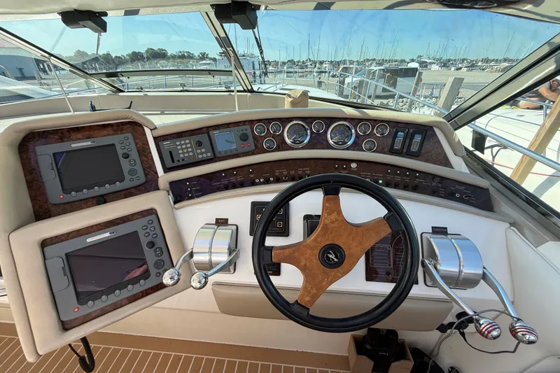 Slide: The Image of Cockpit of a 1994 Sea Ray 500 Sundancer yacht with navigation instruments and steering wheel. - 13