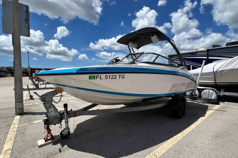 Slide: The Image of 2022 Yamaha Boats AR190 on trailer under blue sky, parked in a lot. - 7