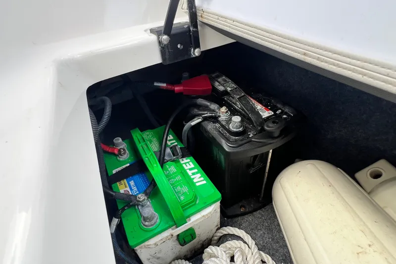 Slide: The Image of Battery compartment of a 2022 Yamaha Boats AR190, featuring dual batteries and marine equipment. - 59