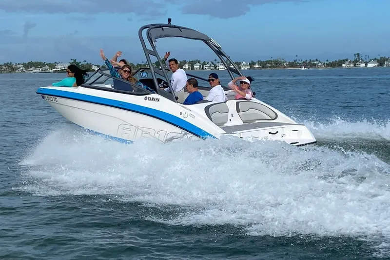 Slide: The Image of 2022 Yamaha Boats AR190 speeding on water with passengers enjoying the ride. - 1