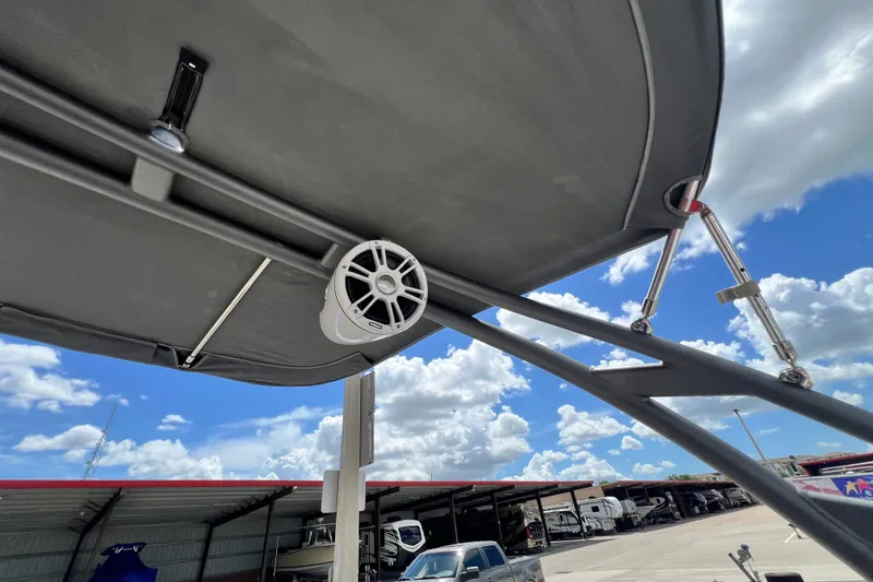 Slide: The Image of 2022 Yamaha Boats AR190 with speaker under canopy, blue sky background. - 23