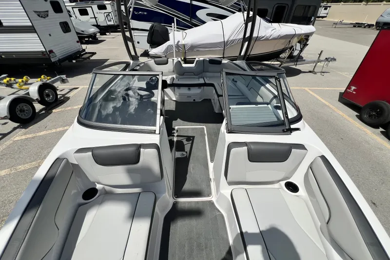 Slide: The Image of 2022 Yamaha Boats AR190 interior view, showcasing seating and windshield in a parking lot setting. - 42