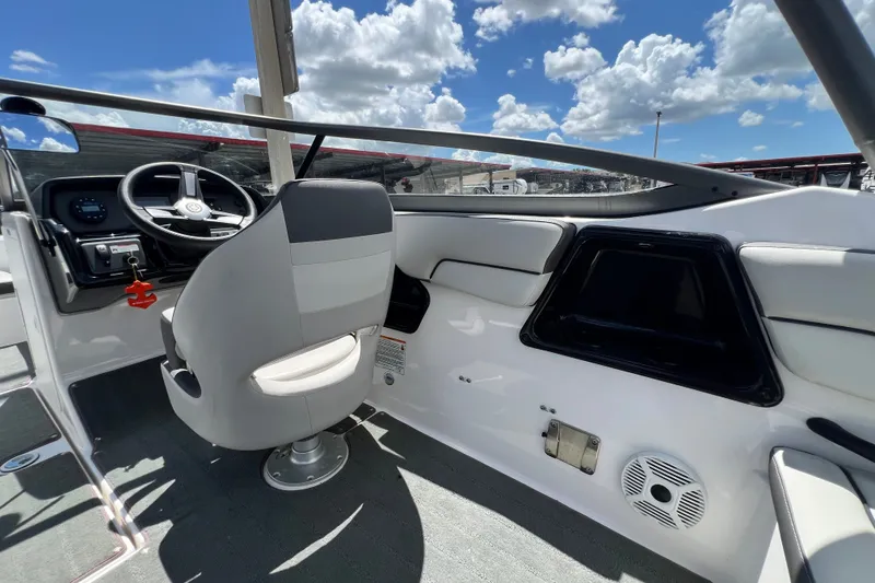 Slide: The Image of 2022 Yamaha Boats AR190 interior with steering wheel, seat, and dashboard under a blue sky. - 22