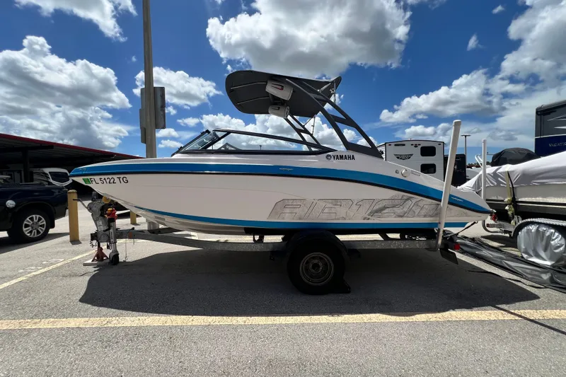 Slide: The Image of 2022 Yamaha AR190 boat on trailer under a partly cloudy sky. - 6