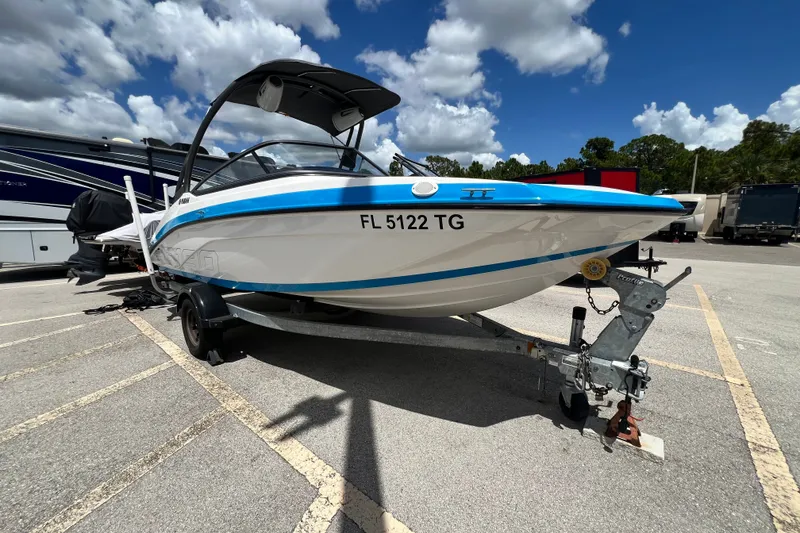 The Image of 2022 Yamaha Boats AR190 on trailer under blue sky, parked in lot. - 0