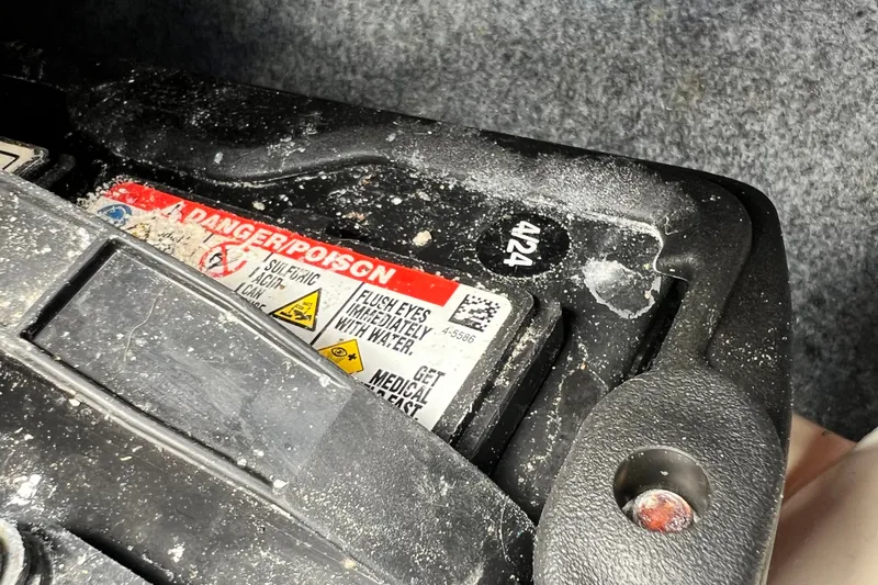 Slide: The Image of Battery compartment of a 2022 Yamaha Boats AR190 with safety warning label. - 60