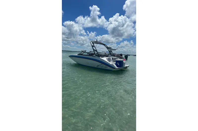 The Image of 2022 Yamaha Boats AR190 floating on clear water under a partly cloudy sky. - 0
