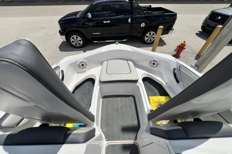Slide: The Image of 2022 Yamaha Boats AR190 interior with seating, parked black truck in background. - 21