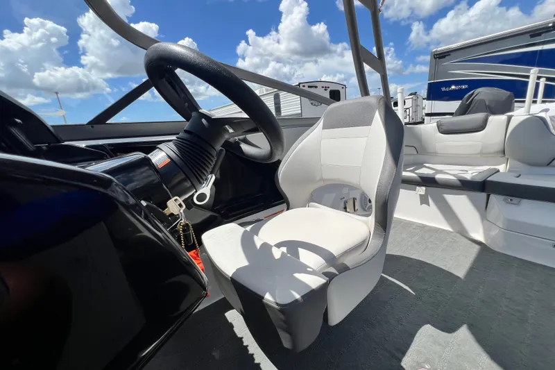 Slide: The Image of 2022 Yamaha Boats AR190 interior with steering wheel and seating under blue sky. - 45