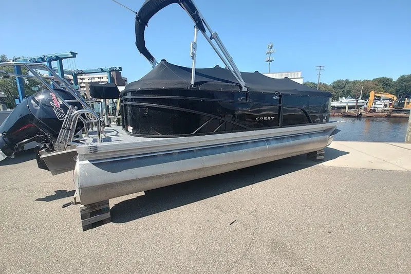 Slide: The Image of 2024 Crest 220SLC Classic LX pontoon boat docked by the water. - 1