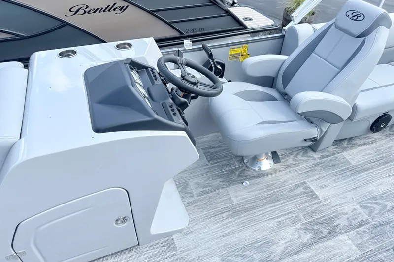 Slide: The Image of 2027 Bentley Pontoons Legacy 200 Navigator helm with luxurious captain's chair and sleek dashboard. - 7
