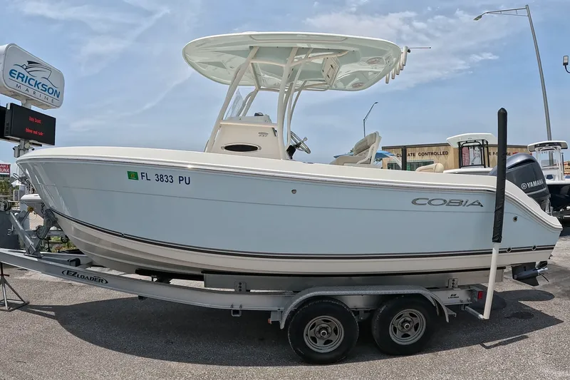The Image of 2015 Cobia 237 Center Console boat on trailer at dealership. - 1