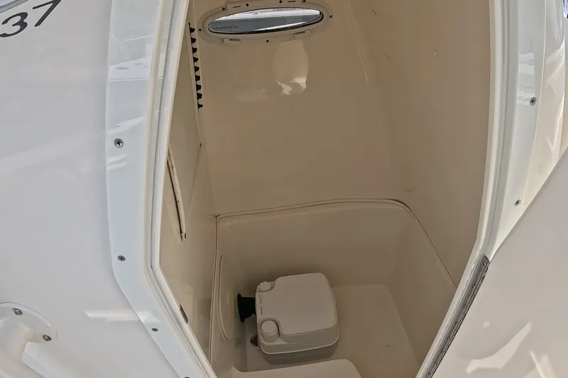 Slide: The Image of 2015 Cobia 237 Center Console boat interior with compact marine toilet. - 17