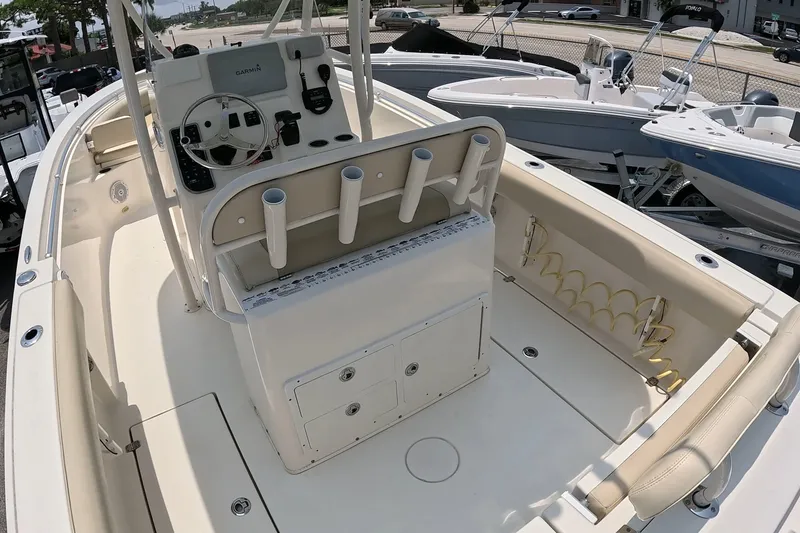 Slide: The Image of 2015 Cobia 237 Center Console boat interior with helm, rod holders, and seating. - 19