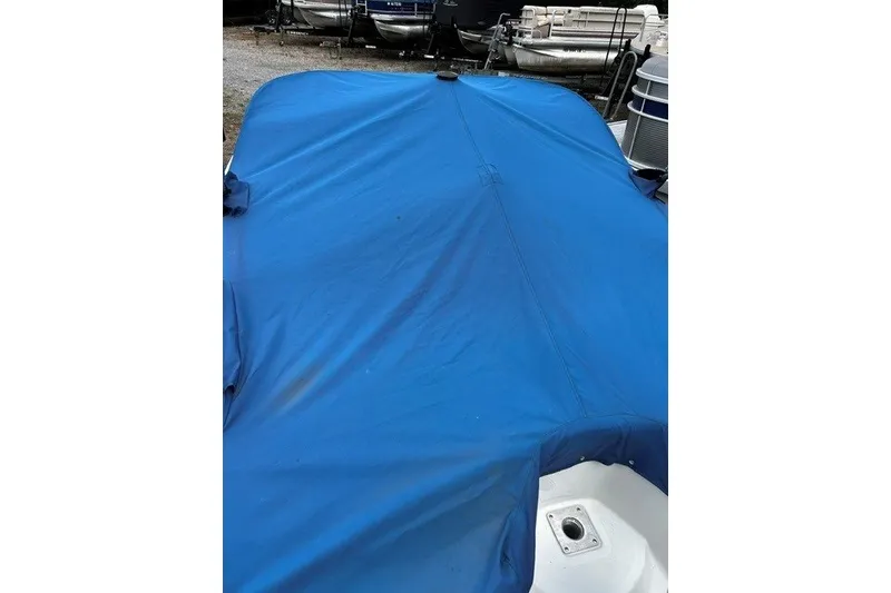 Slide: The Image of Blue cover on 2021 Tahoe 450 TS boat, parked among other boats. - 6