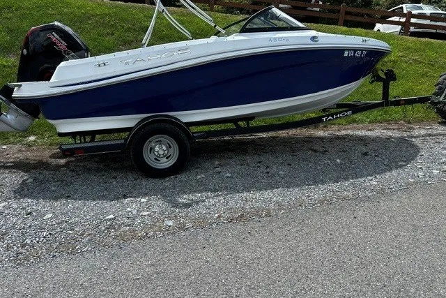 Slide: The Image of 2021 Tahoe 450 TS boat on trailer, parked on gravel road. - 8