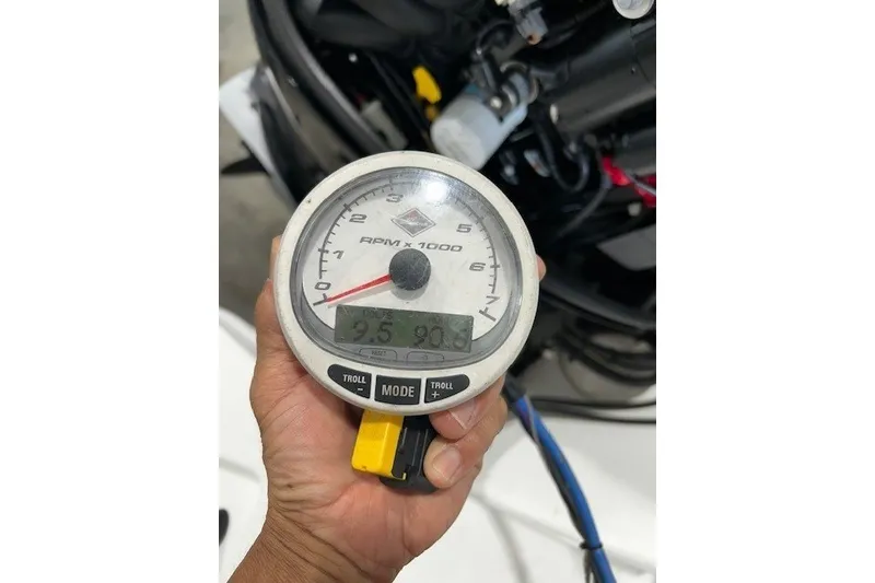 Slide: The Image of Hand holding a tachometer displaying RPM, Tahoe 450 TS 2021 model. - 12