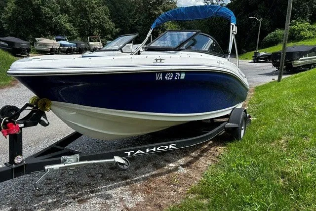 Slide: The Image of 2021 Tahoe 450 TS boat on trailer, parked on a grassy area. - 4