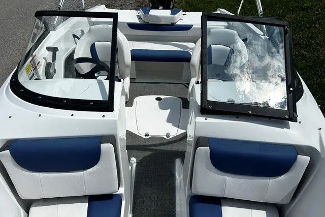 Slide: The Image of 2021 Tahoe 450 TS boat interior with blue and white seating, dual windshields, and steering wheel. - 9