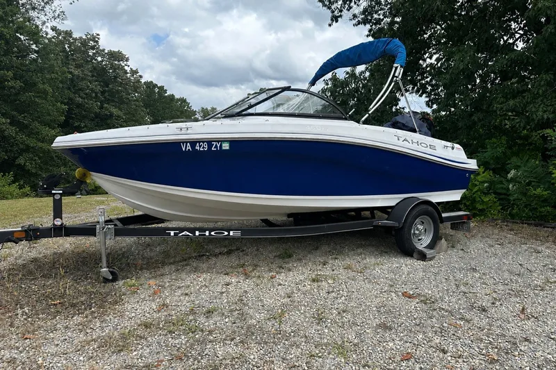 The Image of 2021 Tahoe 450 TS boat on trailer, parked outdoors with trees in background. - 0