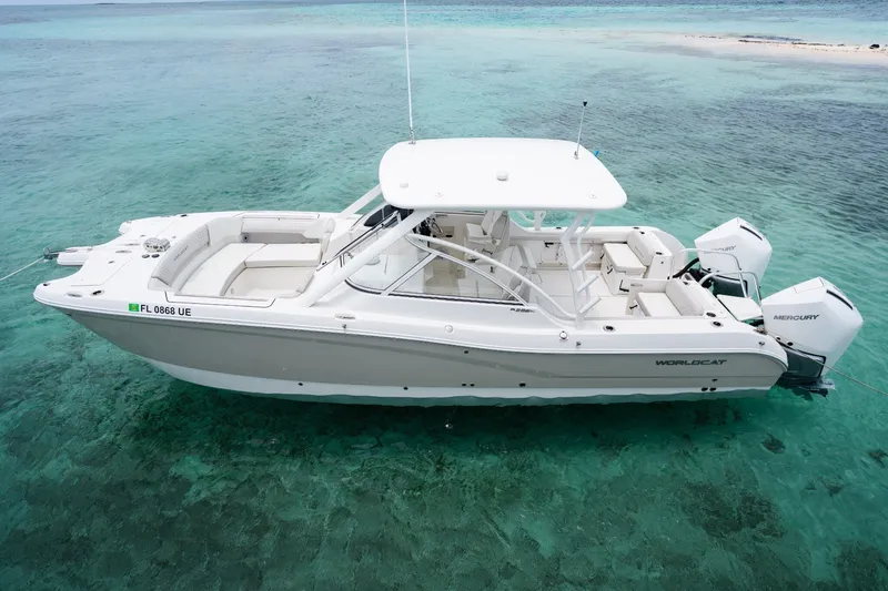 The Image of 2027 World Cat 296 DC boat on clear turquoise water, showcasing sleek design and twin Mercury engines. - 0