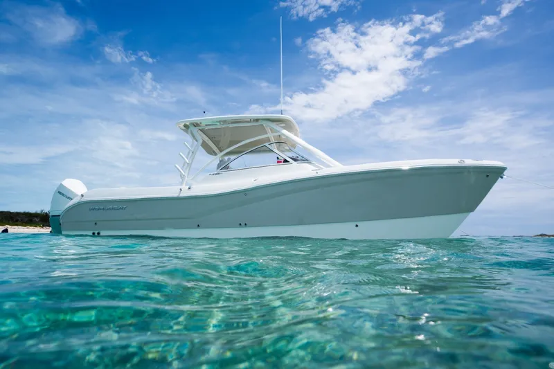 Slide: The Image of 2027 World Cat 296 DC boat on clear turquoise water under a bright blue sky. - 3
