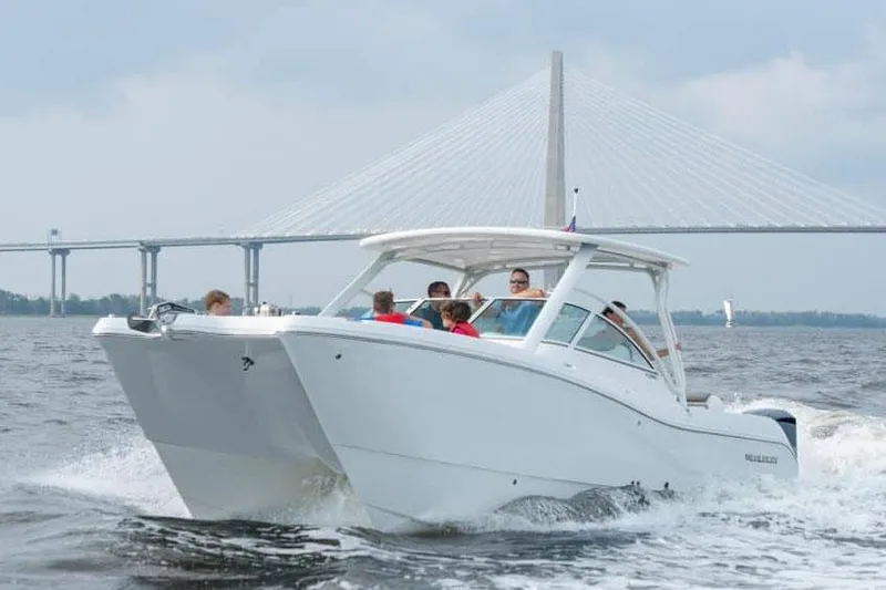 Slide: The Image of Manufacturer Provided Image: 2026 World Cat 296 DC boat cruising near a bridge on a sunny day. - 6