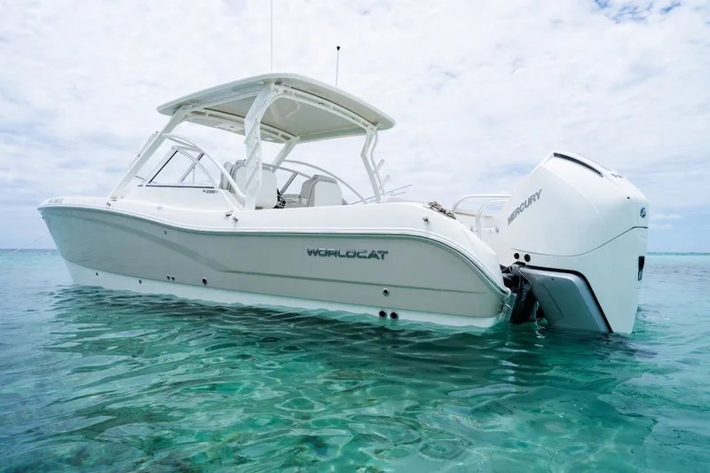 Slide: The Image of 2027 World Cat 296 DC boat on clear turquoise water, featuring Mercury engines. - 2