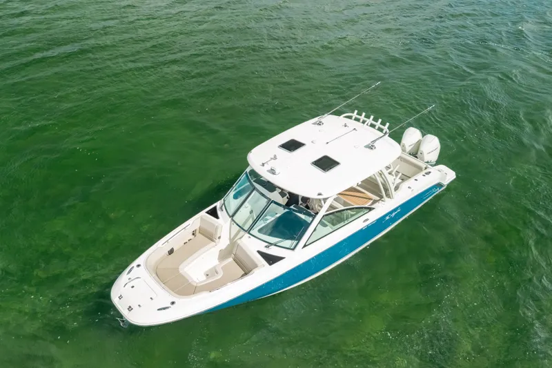 Slide: The Image of 2024 Boston Whaler 320 Vantage boat cruising on clear green water. - 12