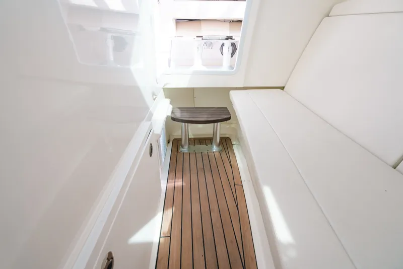Slide: The Image of Interior of 2024 Boston Whaler 320 Vantage with wooden flooring and white seating. - 59