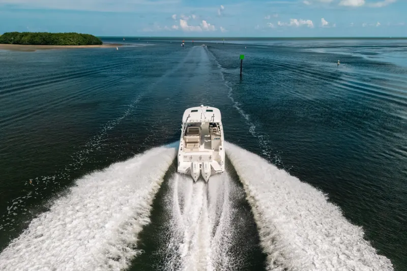 Slide: The Image of 2024 Boston Whaler 320 Vantage cruising on open water, leaving a wake trail. - 21
