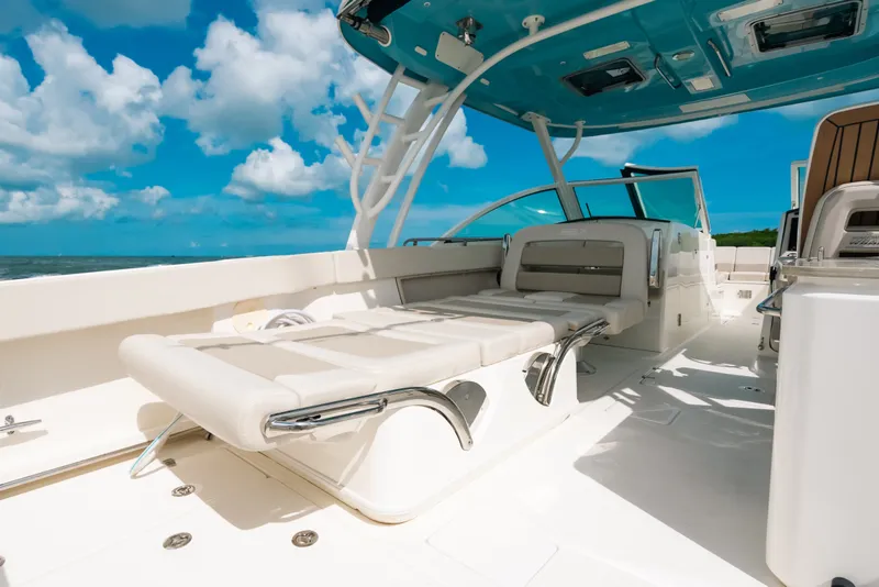 Slide: The Image of 2024 Boston Whaler 320 Vantage boat interior with luxurious seating under blue sky. - 48