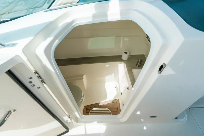 Slide: The Image of 2024 Boston Whaler 320 Vantage boat interior cabin with toilet and wooden flooring. - 45