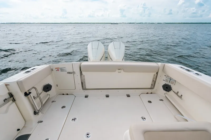 Slide: The Image of 2024 Boston Whaler 320 Vantage boat deck with dual engines on open water. - 26