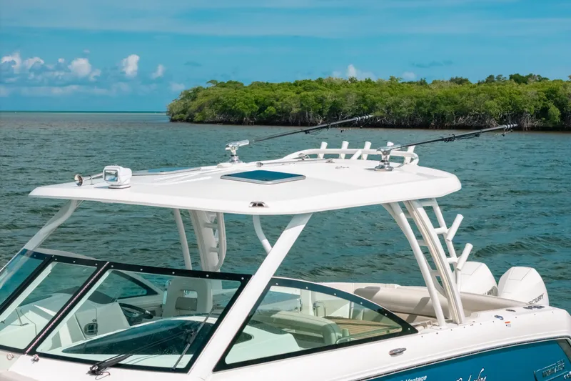 Slide: The Image of 2024 Boston Whaler 320 Vantage boat on water near lush green island. - 17