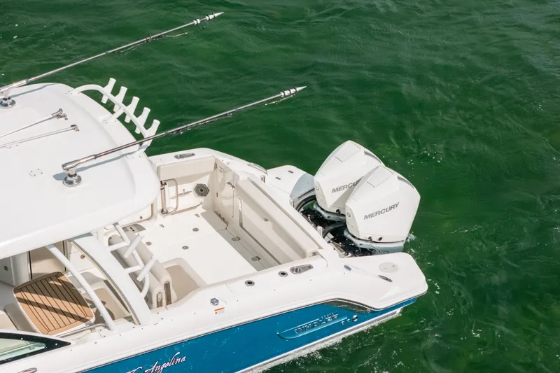 Slide: The Image of 2024 Boston Whaler 320 Vantage boat with dual Mercury engines on green water. - 11