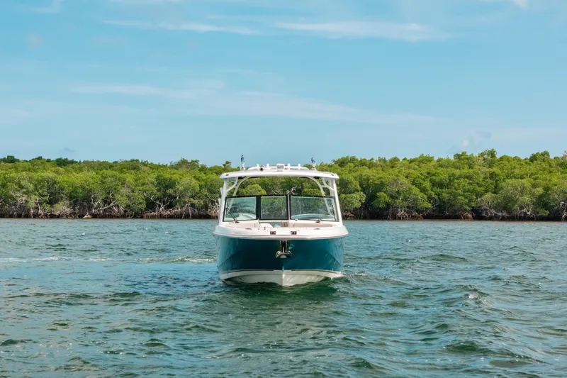 Slide: The Image of 2024 Boston Whaler 320 Vantage boat cruising on a scenic waterway. - 3