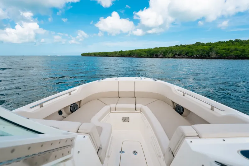 Slide: The Image of 2024 Boston Whaler 320 Vantage cruising on open water under a clear blue sky. - 24