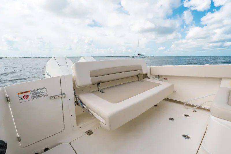 Slide: The Image of 2024 Boston Whaler 320 Vantage boat interior with foldable seating and ocean view. - 29