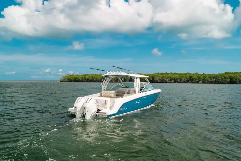 Slide: The Image of 2024 Boston Whaler 320 Vantage cruising on open water under a clear blue sky. - 5
