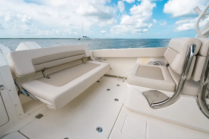 Slide: The Image of 2024 Boston Whaler 320 Vantage boat interior with plush seating, ocean view, and blue sky. - 30