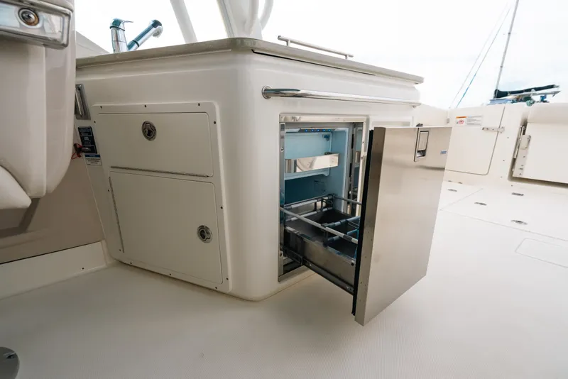 Slide: The Image of 2024 Boston Whaler 320 Vantage boat interior with open stainless steel storage compartment. - 56