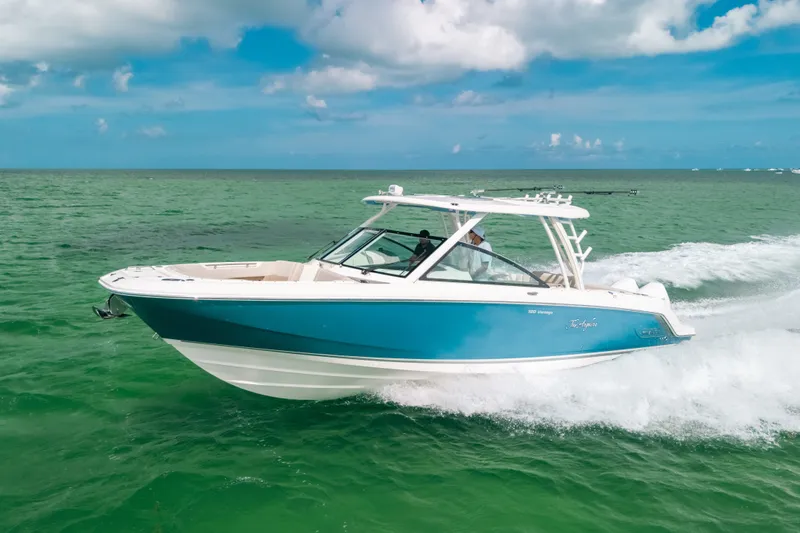 Slide: The Image of 2024 Boston Whaler 320 Vantage cruising on turquoise ocean waters under a clear sky. - 0