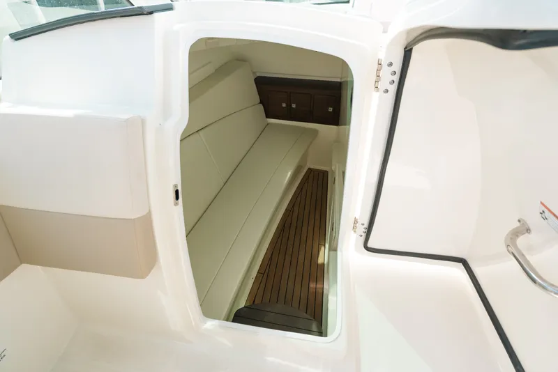 Slide: The Image of 2024 Boston Whaler 320 Vantage cabin interior with seating and wooden flooring. - 60