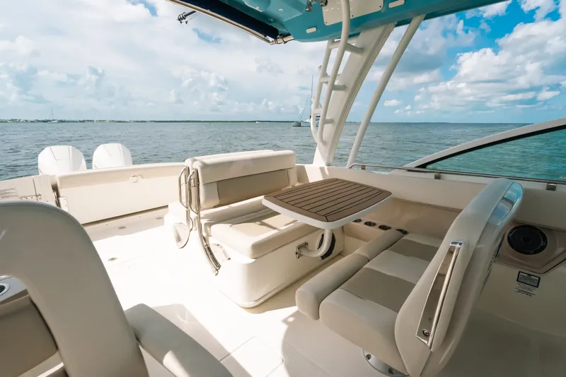 Slide: The Image of 2024 Boston Whaler 320 Vantage boat interior with seating and table, overlooking the ocean. - 40