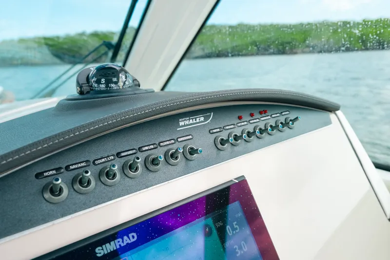 Slide: The Image of 2024 Boston Whaler 320 Vantage dashboard with navigation controls and compass. - 36