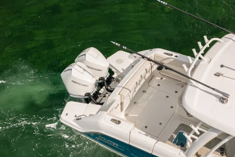 Slide: The Image of 2024 Boston Whaler 320 Vantage boat with dual Mercury engines on green water. - 9